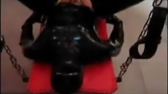 سيدة ترتدي اللاتكس تهيمن على عبدها الذي يستخدم السترابون في عرض كاميرا الويب Bdsm